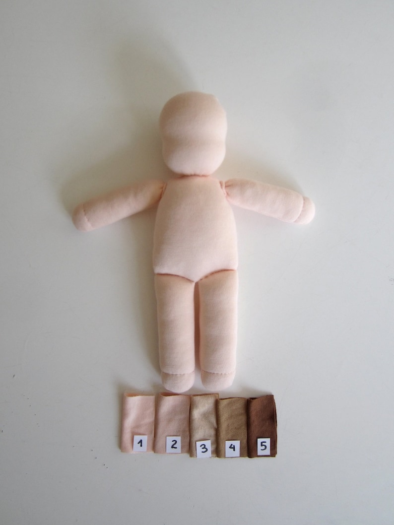 May include: A light pink fabric doll with a simple design. The doll is laying on a white surface with five fabric swatches labeled 1 through 5.