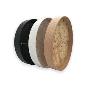 Op de afbeelding: Drie ronde houten dienbladen, een zwart, een wit en een met een natuurlijke houten afwerking. Het dienblad van natuurlijk hout heeft een zichtbare multiplexconstructie.