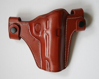 May include: A brown leather holster with white stitching and a black snap closure.