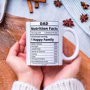 May include: White ceramic mug with a black and white graphic that reads "DAD Nutrition Facts" with a list of qualities and a percentage daily value for each. The qualities listed are Strength, Leadership, Sense of Humor, Caring, Pride, Wrong Answers, and Unconditional Love. Each quality has a percentage daily value of 100%.