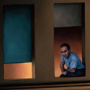 May include: A man in a blue shirt sits in a window, looking out at the viewer. The window is framed in wood and has a blue and orange background.