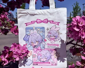 Pode incluir: Bolsa tote branca com um gráfico colorido em estilo anime com um personagem com cabelo roxo e orelhas de coelho. O design inclui laços rosa, molduras semelhantes a computadores e a palavra "Sunday". A bolsa tem alças brancas.