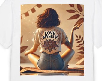 May include: White t-shirt with a graphic print of a woman sitting with her back to the viewer. The woman is wearing denim shorts and a white t-shirt with the text "LOVE MYSELF" on the back. The graphic is set against a background of brown leaves and a sunset.