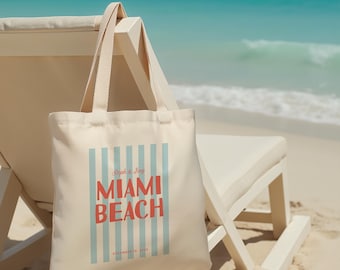 Può includere: Una borsa di tela bianca con strisce blu e bianche e il testo "Ryan & Amy Miami Beach December 12, 2020" in rosso e bianco.