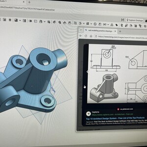 May include: A computer screen displaying a 3D CAD model of a mechanical part with a central cylindrical hub, three mounting flanges, and a triangular support rib, alongside a browser window showing technical engineering drawings.