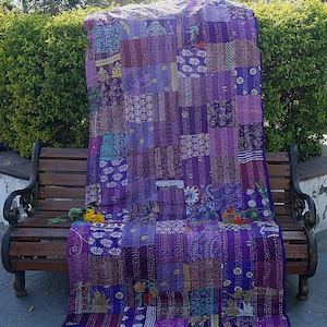 Puede incluir: Una colcha kantha morada con un diseño de patchwork. La colcha está hecha de varios tonos de morado y presenta puntadas intrincadas.