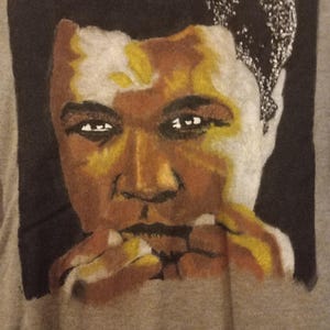 May include: A black and white portrait of a man with a serious expression. The man is wearing a white shirt and has a dark complexion. The portrait is painted in a realistic style.