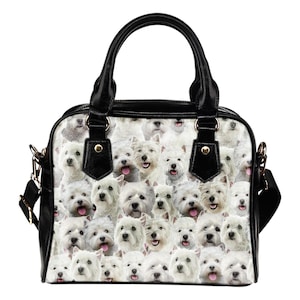 Peut inclure: Sac à main noir et blanc avec un motif répété de West Highland White Terriers. Le sac a une poignée noire, une garniture et une bandoulière. Les chiens sont blancs avec des yeux et des nez noirs, certains avec la langue sortie.