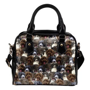 May include: Black and white handbag with a repeating pattern of various dog breeds. The bag has a black handle, black trim, and a detachable shoulder strap with gold-colored hardware. The dogs are in shades of brown, gray, and black.