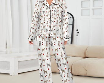 May include: White pajama set with a dog and heart pattern. The long-sleeved top and pants have black trim and buttons. The pajamas are made of a soft, silky material.