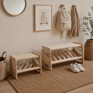 Può includere: Due scarpiere in legno di colore chiaro con ripiani inclinati e pannelli laterali aperti. La scarpiera più grande è posizionata a destra di quella più piccola, con un paio di scarpe da ginnastica bianche appoggiate sul pavimento davanti.