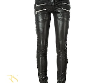 May include: Black leather pants with multiple silver zippers and decorative stitching. The pants have a fitted design with a classic five-pocket style and lace-up detailing on the sides. The pants are from Rogue Studs.