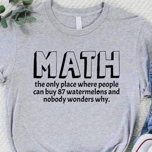 May include: Gray t-shirt with black text that reads "MATH the only place where people can buy 87 watermelons and nobody wonders why."