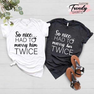 May include: Two white t-shirts with black text. The text on the left shirt reads "So nice... HAD TO marry him TWICE". The text on the right shirt reads "So nice... HAD TO marry her TWICE".