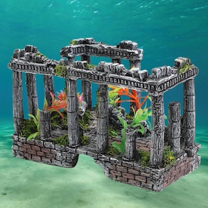 Op de afbeelding: Een grijs en wit aquarium ornament in de vorm van een verwoeste tempel met kolommen en bogen. Het ornament is versierd met groene en oranje plastic planten.