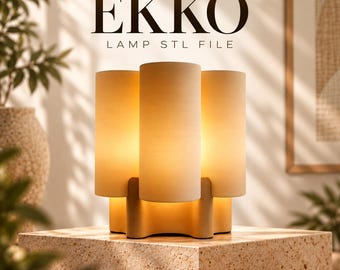 Puede incluir: Una lámpara de mesa con tres pantallas cilíndricas verticales en acabado beige mate, dispuestas alrededor de una base central. El texto EKKO LAMP STL FILE aparece sobre la lámpara. La lámpara emite un brillo cálido y suave desde los cilindros.