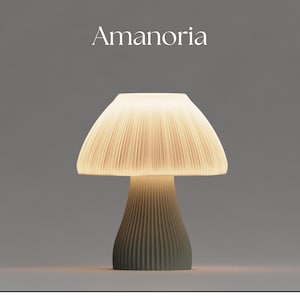 May include: A white ceramic mushroom-shaped table lamp with a pleated shade and a green base. The lamp is lit and casting a warm glow.