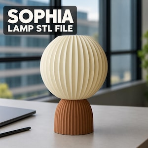 Puede incluir: Una l&aacute;mpara de mesa con una pantalla esf&eacute;rica de color crema con nervaduras verticales y una base m&aacute;s peque&ntilde;a de color marr&oacute;n con nervaduras verticales. El texto 'SOPHIA LAMP STL FILE' aparece en un recuadro negro en la esquina superior izquierda.