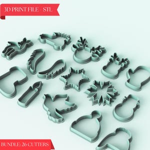 Peut inclure: Un ensemble de 26 emporte-pièces de Noël de formes variées, dont une étoile, un flocon de neige, un renne, un ange et une chaussette. Les emporte-pièces sont en plastique bleu clair et sont disposés sur un fond bleu clair. Le texte "BUNDLE: 26 CUTTERS" est visible en bas de l'image.