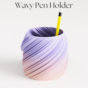 Könnte beinhalten: Ein wellenförmiger Stiftehalter aus 3D-gedrucktem Kunststoff mit einem Farbverlauf von Lila zu Rosa. Ein gelber Bleistift ragt oben heraus.