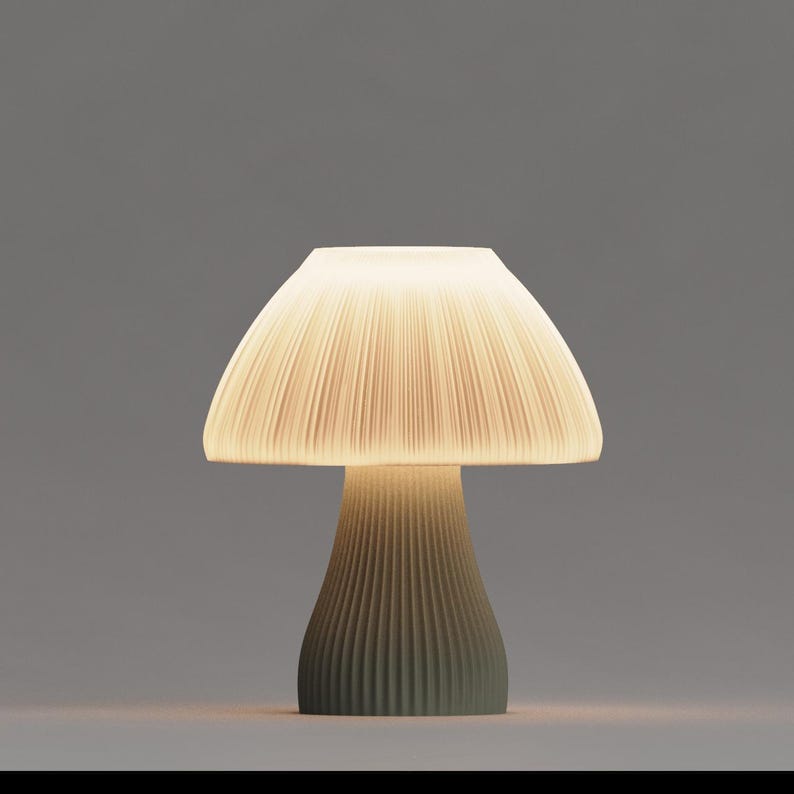 May include: A white ceramic mushroom-shaped table lamp with a pleated shade and a green base.