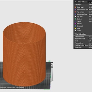 Puede incluir: Un modelo 3D de un objeto cil&iacute;ndrico con una superficie texturizada. El modelo es de color naranja y se muestra en una cuadr&iacute;cula en blanco y negro. La imagen incluye una tabla que muestra la estimaci&oacute;n del uso de filamento, el costo y el tiempo de impresi&oacute;n.