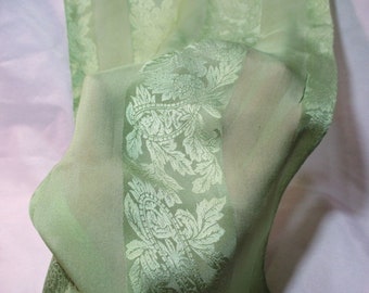 A Long, Vintage Light Green Shimmering Scarf with a Jacquard Print of Leaves with Paisley Designs.