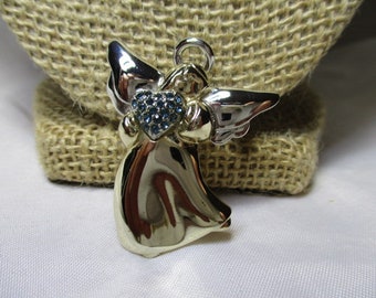 A Vintage LIZ CLAIBORNE SIlver and Gold Tone Angel Pin/Brooch Holding a Sapphire-like Jeweled Heart.