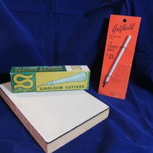May include: A Speedball linoleum cutter set in a green and white box, a Grifhold #3 stencil knife on an orange display card, and a rectangular wooden block. The stencil knife card features the text Grifhold, Precision Hand Tools, #3 Stencil Knife, and .25.