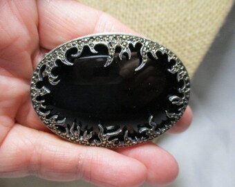 A 1920's Large Oval Sterling Silver Brooch Framed with Shimmering Marcasites Against Black Glass Cabochon.