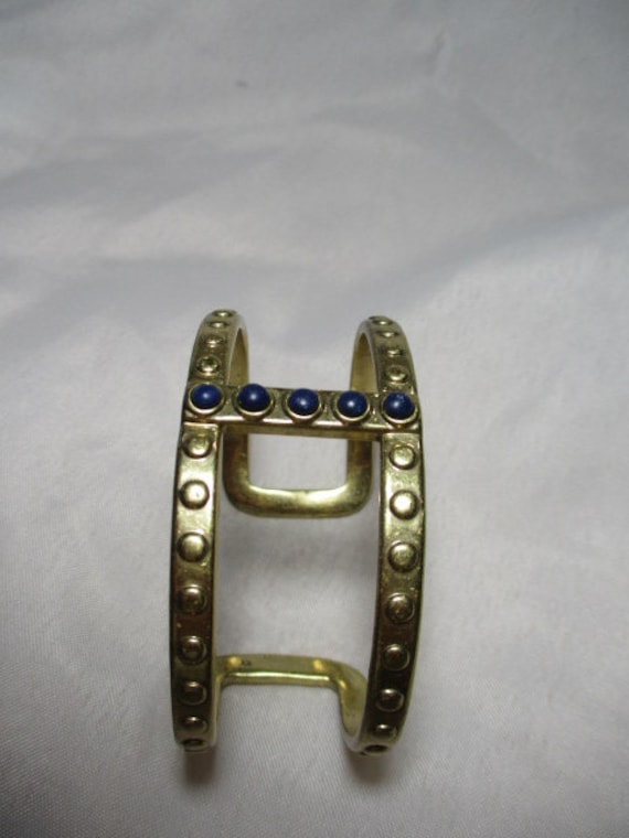 A 2003 LUCKY BRAND Gold Tone Cuff Bracelet With Blue Cabochon Accents. 