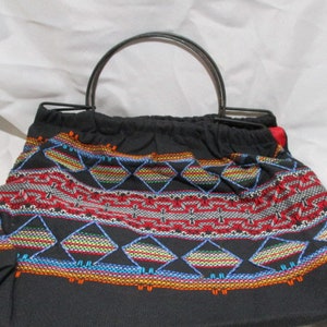 Un bolso/cartera peruano bordado a mano, de color negro, año 2004.