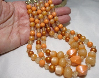 A 1950's Triple Strand of Light Orange Moon Glow, Simulated Pearls & Crystal-like Beads Beaded  Necklace.