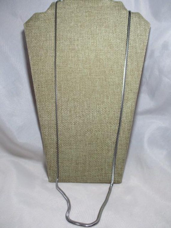 A Thirty-Four Inch, Silver Tone Flat Snake Chain Necklace.