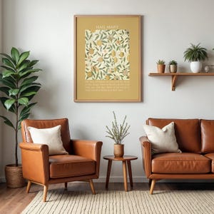May include: A framed wall art print featuring the text HAIL MARY at the top, a central square illustration of botanical fruit and leaf patterns in muted tones, and a prayer text at the bottom, all set against a solid mustard yellow background.