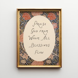 May include: A framed art print featuring the phrase "Praise God From Whom All Blessings Flow" in a decorative script. The central oval is cream-colored, surrounded by a floral design in red, orange, and blue, set within a gold-colored frame.