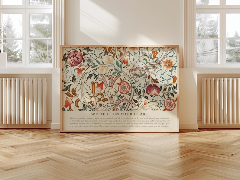 May include: A framed art print featuring a floral design with red, orange, and cream colors. The artwork includes the text "WRITE IT ON YOUR HEART" at the bottom. The print is displayed in a room with natural light.
