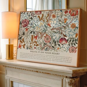 May include: A framed floral art print with a wooden frame. The artwork features a detailed pattern of flowers and foliage in shades of red, cream, and brown. The text "WRITE IT ON YOUR HEART" is visible at the bottom.