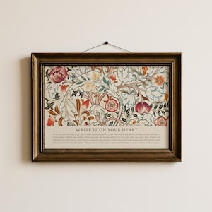 May include: A framed print with a floral design in shades of red, orange, blue, and cream. The print is in a dark brown wooden frame and has the words "WRITE IT ON YOUR HEART" at the bottom.