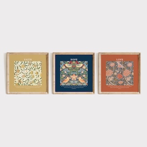 May include: Three framed art prints, each with a different floral design and the words "Faith", "Hope", and "Love". The prints are in wooden frames and are displayed on a white background. The designs feature shades of yellow, blue, and orange.