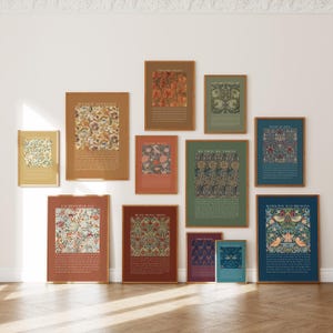 Könnte beinhalten: Eine Sammlung gerahmter Kunstdrucke mit floralen und botanischen Designs. Die Drucke zeigen verschiedene Farben, darunter Gold, Braun, Grün und Blau, mit Text am unteren Rand. Die Rahmen haben eine goldene Oberfläche, und die Drucke sind an einer weißen Wand angeordnet.