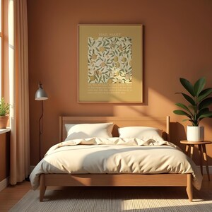 May include: A square framed wall art print featuring a yellow background with a botanical pattern of green leaves and fruit, topped with the text HAIL MARY and a prayer at the bottom, displayed above a wooden bed frame with white bedding.