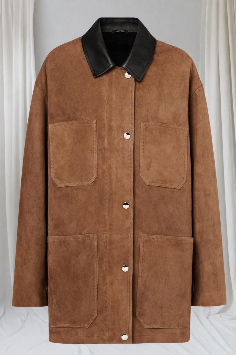 May include: A brown suede jacket with a black leather collar. The jacket has four front pockets and silver button closures. The garment is a classic style, suitable for various occasions.
