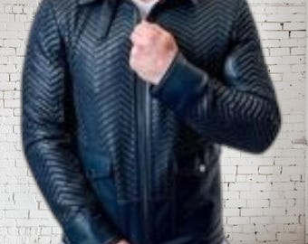 May include: A navy blue leather jacket with a chevron pattern. The jacket has a collared neckline, a zipper closure, and two front pockets. The sleeves have a textured design. The person is wearing a white shirt underneath.
