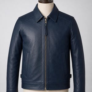 May include: A dark navy blue leather jacket featuring a classic point collar, a full-length metal front zipper with a matching leather pull tab, two vertical side pockets, and adjustable side waist tabs, displayed on a neutral mannequin torso.