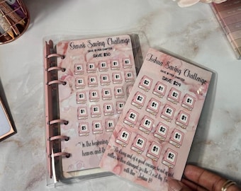 May include: Pink and white saving challenge cards with book illustrations and dollar amounts. One card reads "Genesis Saving Challenge" and the other "Joshua Saving Challenge". The cards are in a clear binder.