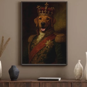 May include: A framed portrait of a dog wearing a crown and military-style attire. The dog has a golden coat and is depicted with a regal expression. The artwork features a red sash and gold embellishments, set against a dark background.