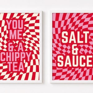 May include: Two framed rectangular wall art prints with white frames. The left print features a red and white wavy checkerboard pattern with the pink text YOU, ME & A CHIPPY TEA. The right print has a red and pink wavy checkerboard pattern with the white text SALT & SAUCE.