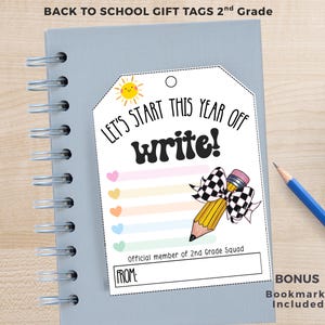 May include: A white rectangular gift tag with rounded top corners featuring the text LET'S START THIS YEAR OFF write!, a yellow sun, a pencil with a black and white checkered bow, pastel hearts, and the text Official member of 2nd Grade Squad.