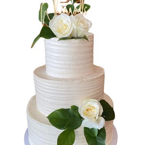 Dreistöckige Fake-Torte mit elfenbeinfarbenen Blumen
